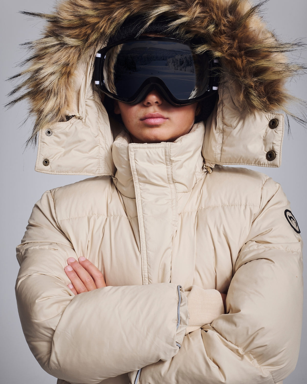 Kids' Winter Coats featuring a stylish puffy coat with faux fur hood and ski goggles for warmth and fashion.