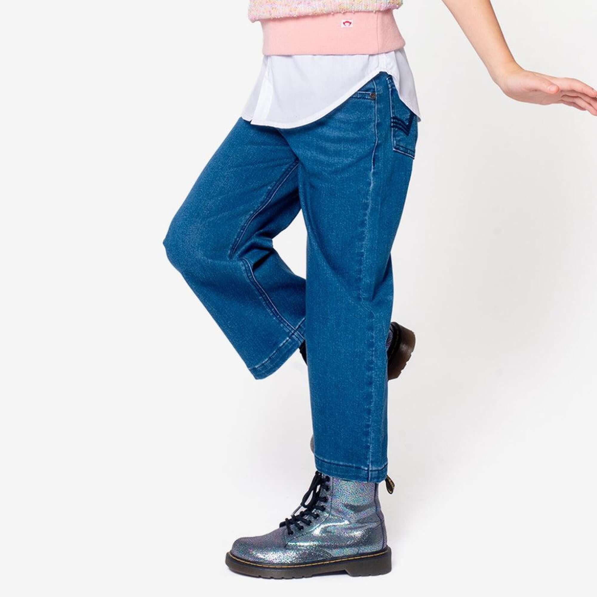 Girl wearing stylish Girls' Denim Jeans with shiny boots, showcasing playful childhood fashion.