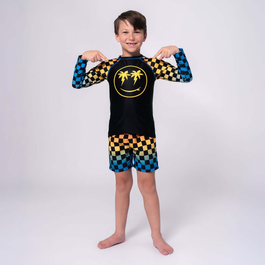 Stylish boy in a bright rash guard with palm trees, ready for fun in the sun at the beach or pool!