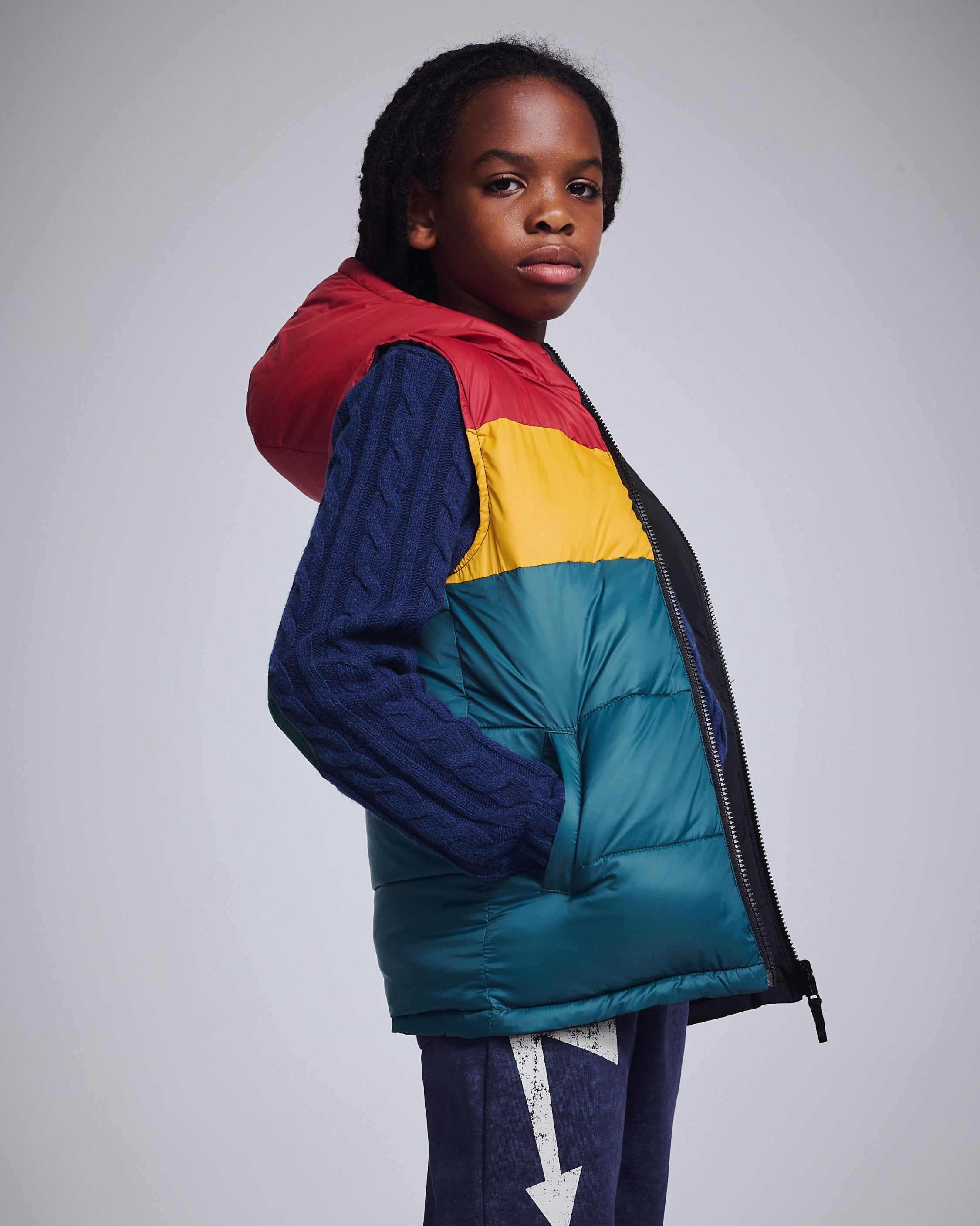 Stylish boy in a cozy black vest over a playful blue hoodie, perfect for keeping warm while looking cool!