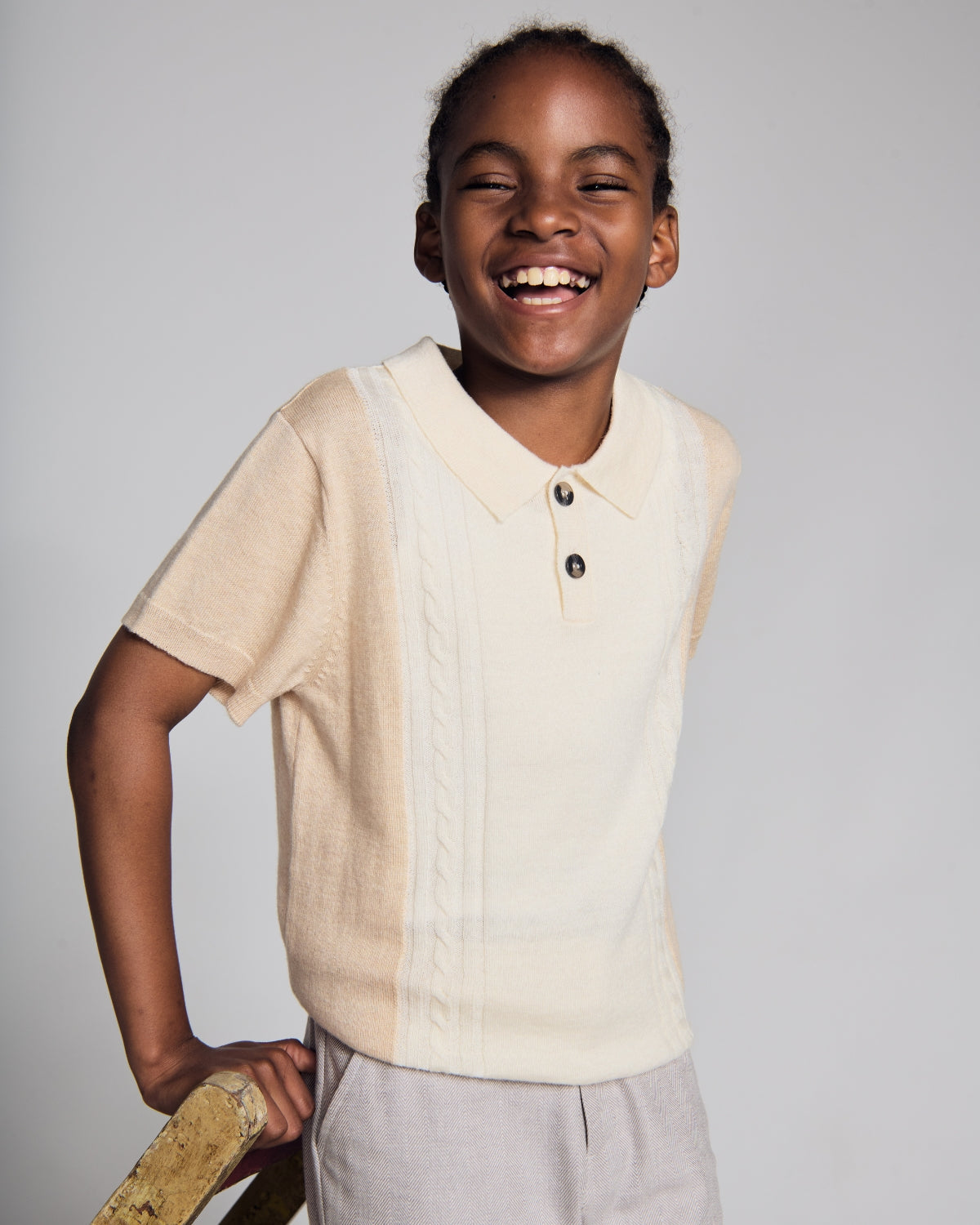 Boys' Sweaters: A boy wearing a cozy navy sweater with a colorful vest, showcasing style and comfort for sweater season.