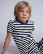 Child wearing a blue and white striped shirt against a plain background