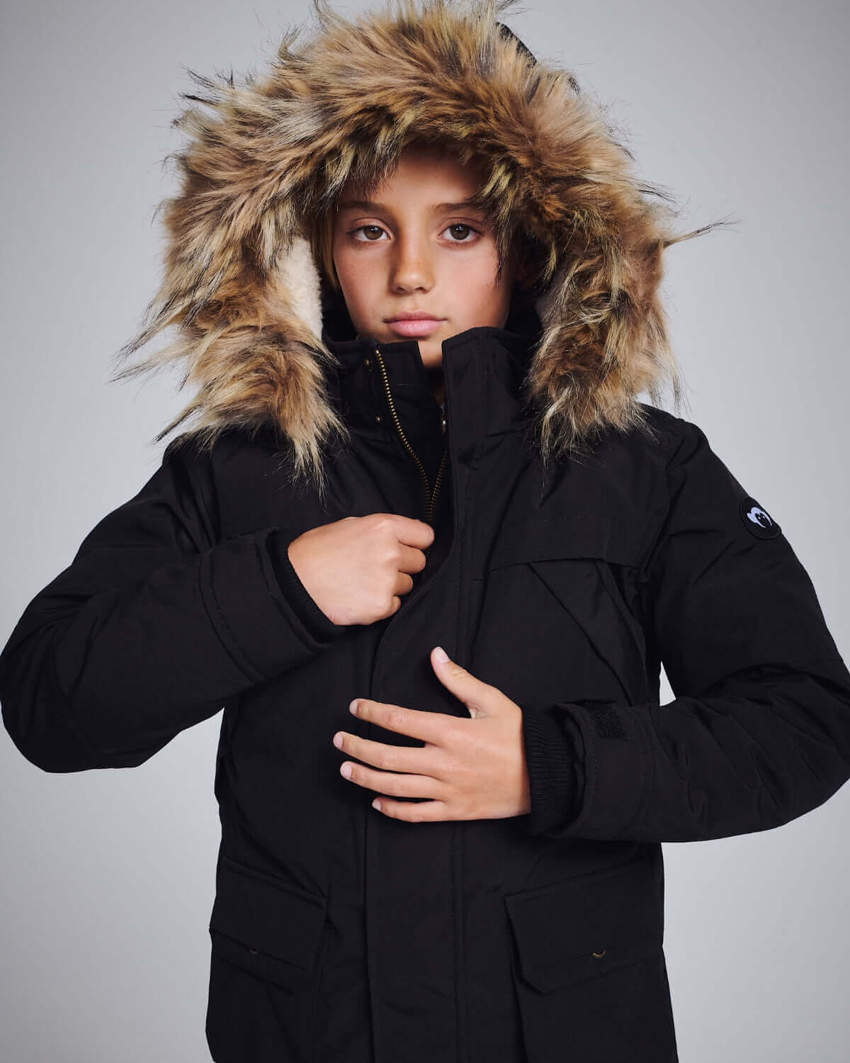 High-quality kids clothing, featuring a child in a warm winter jacket with a fur-lined hood.