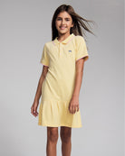 Girl wearing the Buttercup Polo Pleated Dress with short sleeves and pleated skirt.