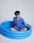 Child wearing a Cobalt Blue Terry Resort Shirt sitting in a blue inflatable pool, styled for summer fun.