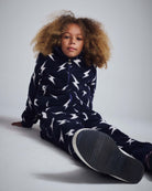 Kid wearing an Electrifying Fleece Sweatsuit Set featuring a bold lightning bolt print and a cozy zip-up jacket.