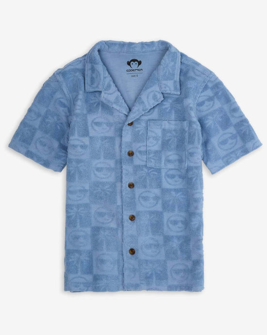 Blue Resort Terry Shirt in denim blue with playful palm trees and smiley faces wearing sunglasses.