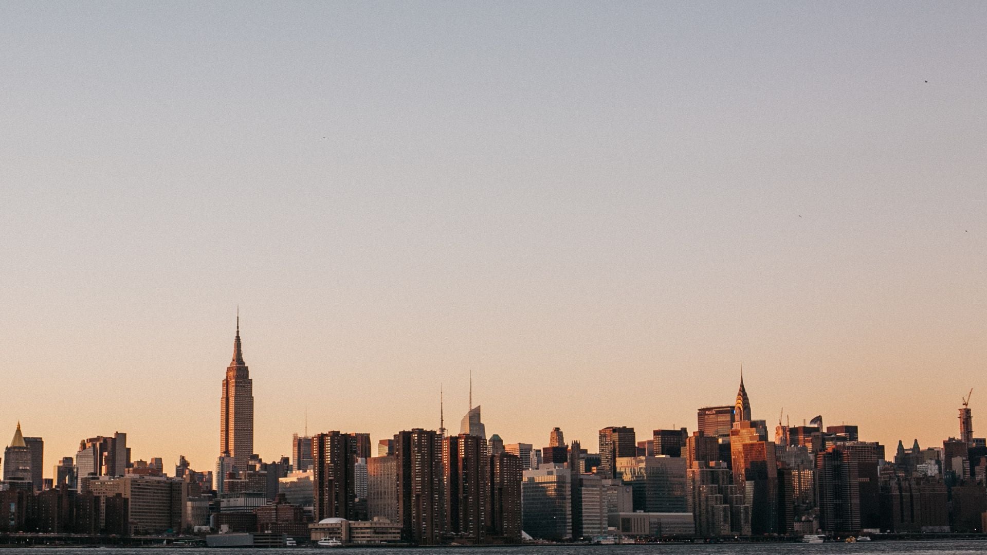 City skyline with prominent buildings against a sunset sky