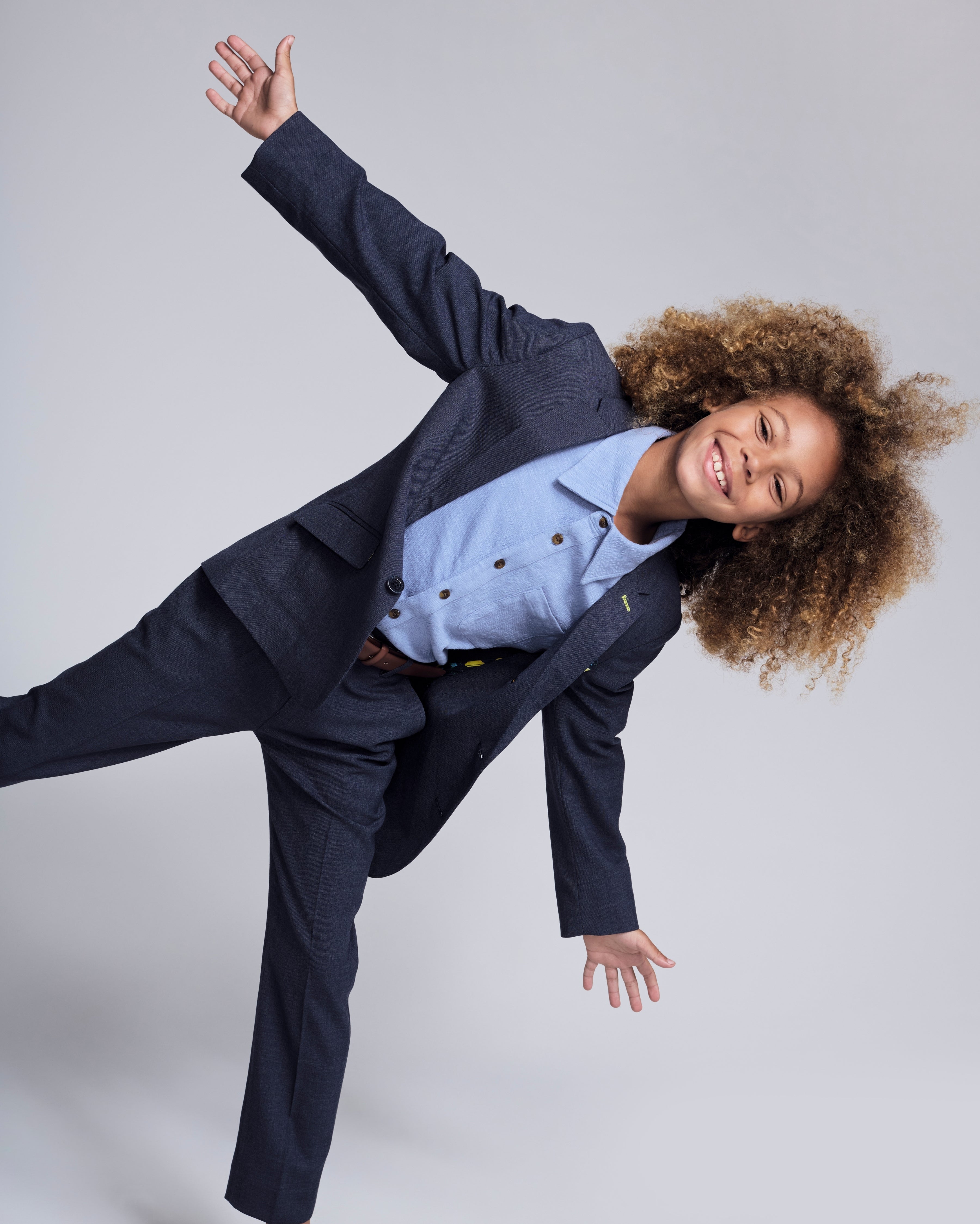 A joyful child wearing a stylish Glacier Lake Beach Shirt with a suit, showcasing playful summer fashion.