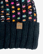 Black knit beanie with colorful fox patterns and a brand label on a white background