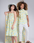 Two children wearing fresh summer outfits with lemon prints, showcasing the Lemon Zest Day Party Shirt.
