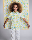 Linen White Windowpane Resort Pant model wearing a lemon print shirt and posing with a matching background.
