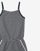 Black and white striped dress with polka dot straps on a light gray background