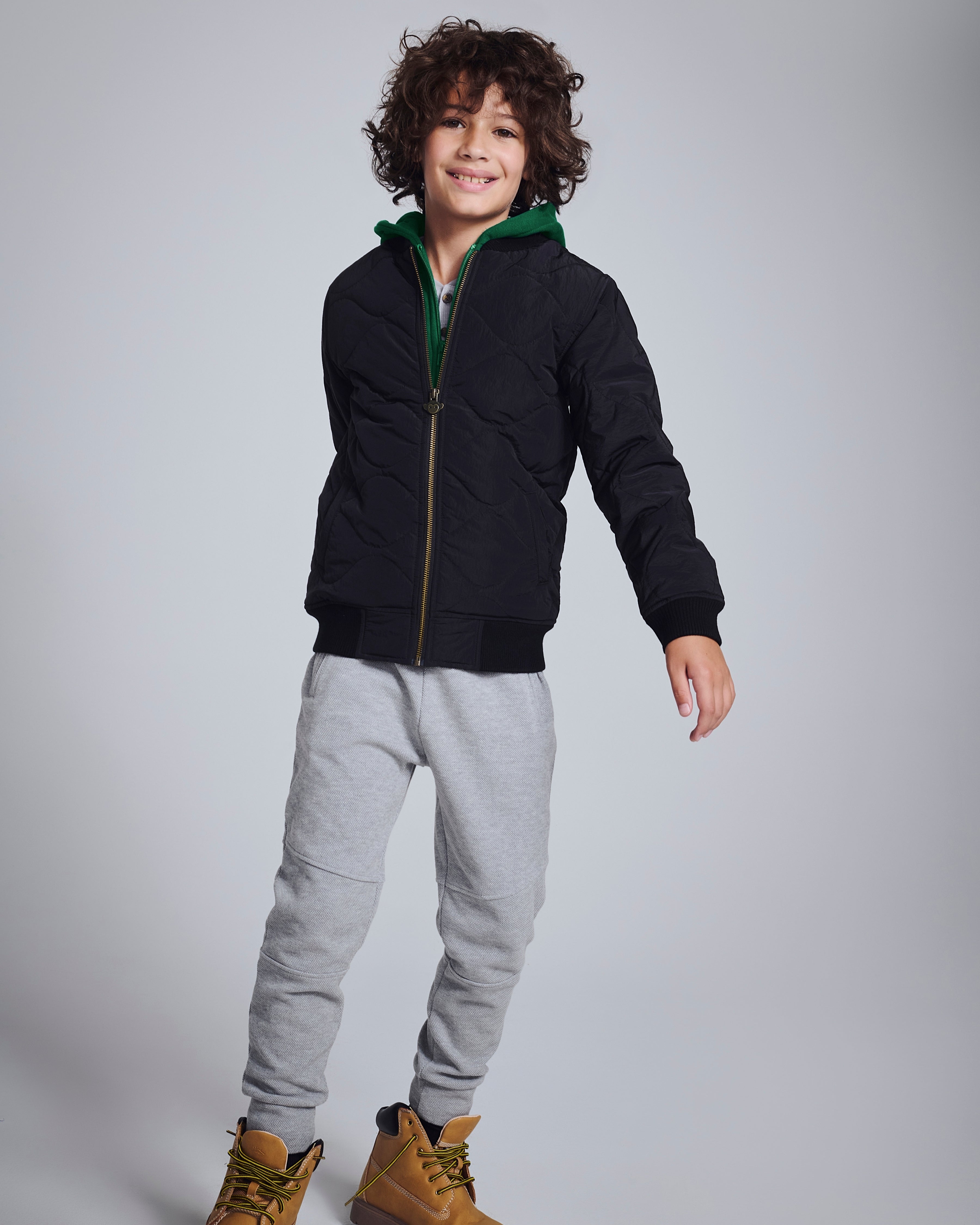 Child wearing Novelty Grey Heather Sideline Sweatpants with a black jacket and stylish boots.