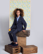 Boy wearing Peacoat Stretchy Mod Suit, stylish suit with a lined jacket and adjustable pants, posing with a lemon.