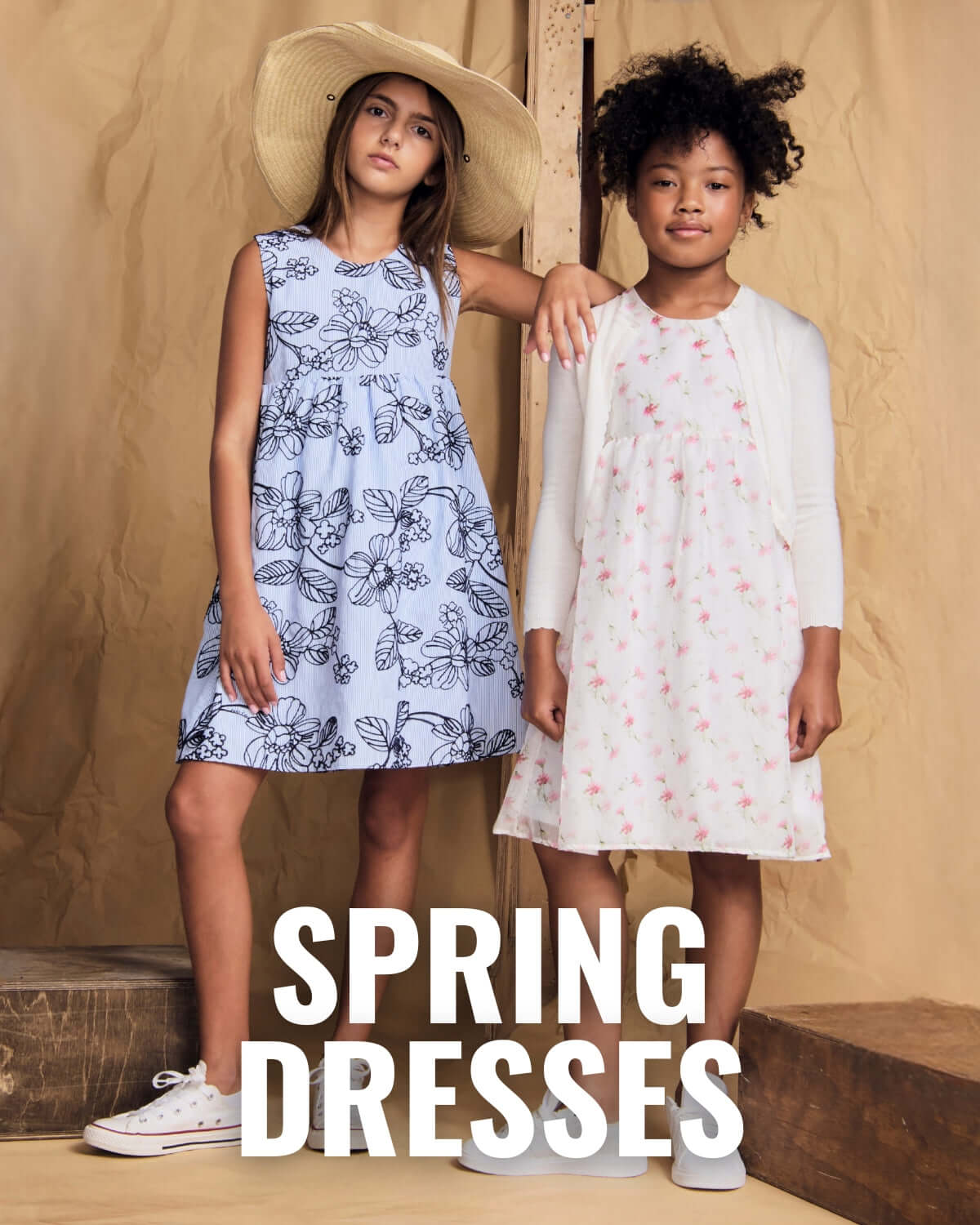 two girls in spring dresses blue dress with florals and white dress with pink flowers