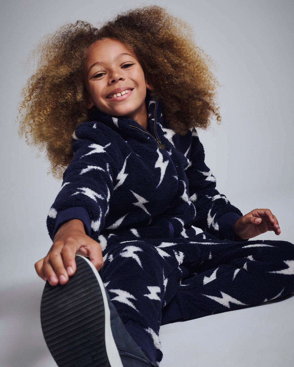 a girl in pajamas with a shoe on her foot