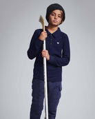 Child wearing a navy blue outfit with a logo on a plain background