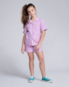 Girl wearing Sunny Days Terry Lilac Resort Short and matching shirt, perfect for summer fun and style.