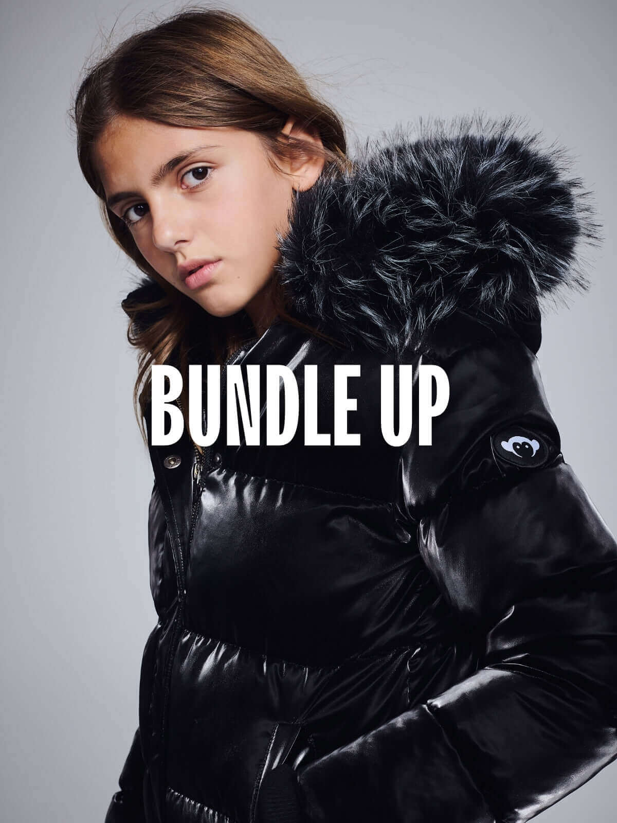 High-quality kids clothing featuring a stylish black puffer jacket with a faux fur hood for warmth.