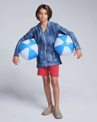 Boy wearing the Washed Red Preston Short and blue beach balls, ready for summer fun.