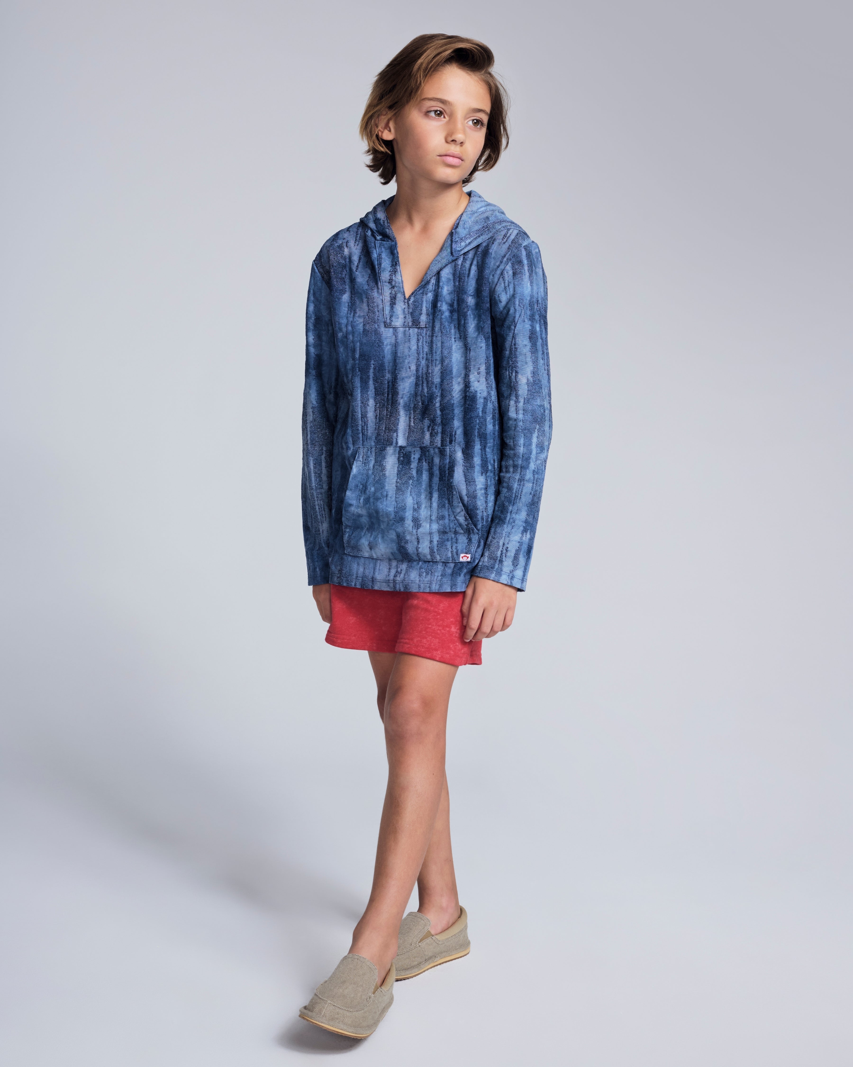 Boy wearing Waterfall Terry Baja Pullover with a tie dye pattern and matching shorts.