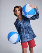 Boy wearing Waterfall Terry Baja Pullover, holding beach balls, styled for summer fun.