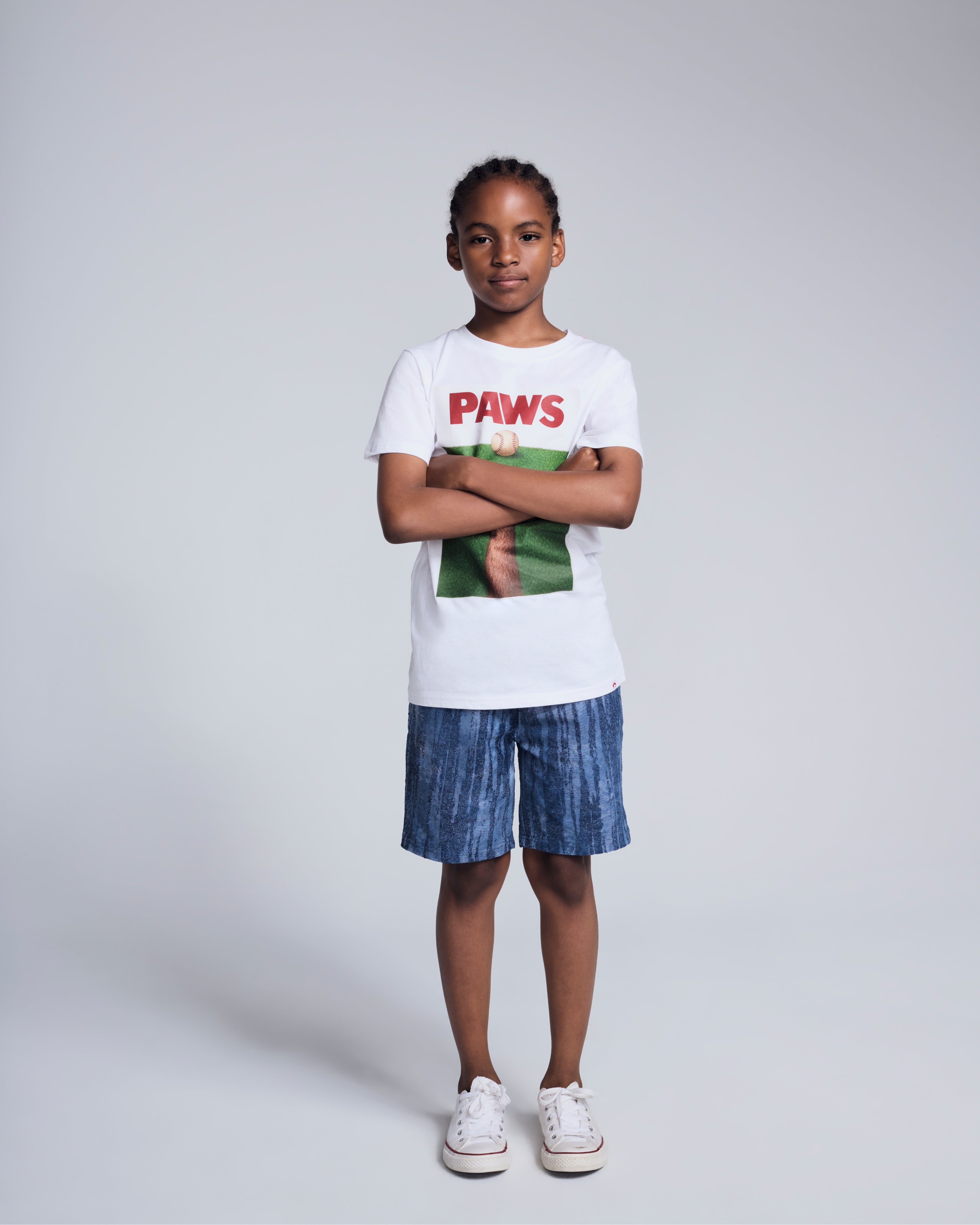 Child wearing Waterfall Preston Short and Paws t-shirt, posing against a neutral background.