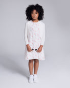 Child wearing a White Bolero Cardigan over a floral dress, ready for spring events.