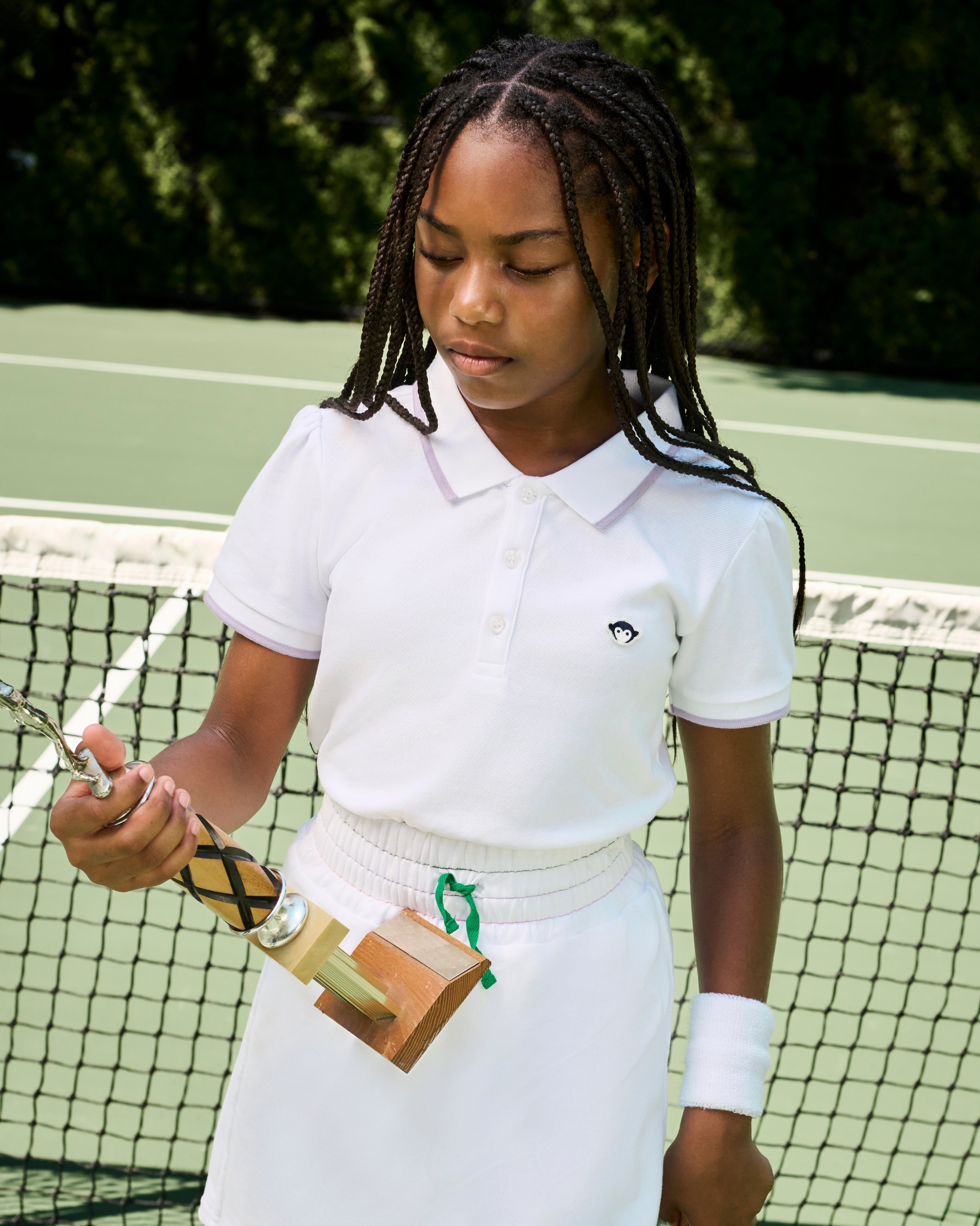 Young girl holding a tennis racket on a tennis court