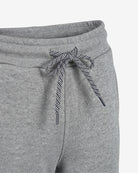 Close-up of gray heather sweatpants with a black and white striped drawstring tied in a bow at the waistband.
