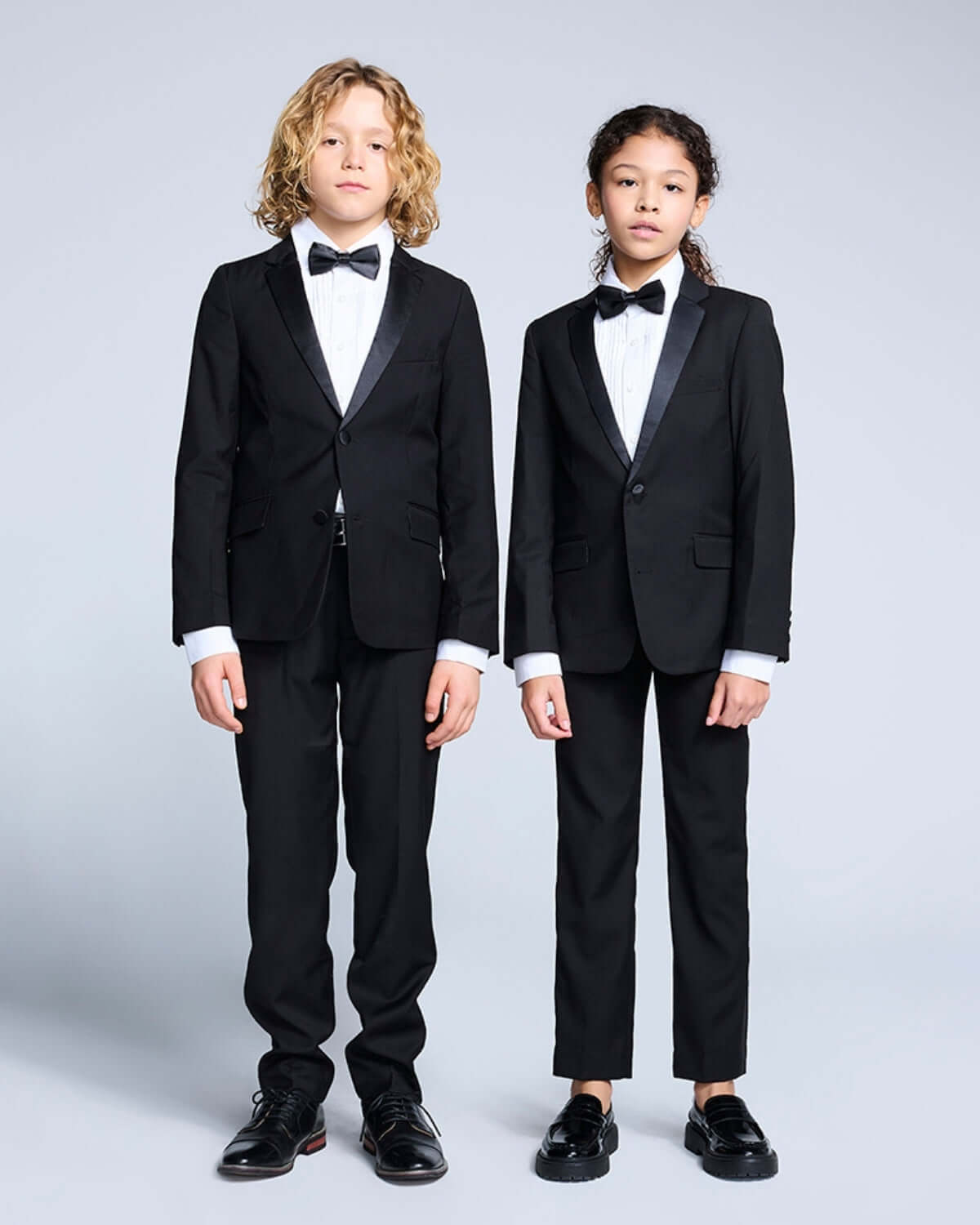 Tuxedo Suit Bundle 3-Piece Set showcased by two children in matching tuxedos, including bow ties and formal dress shirts.