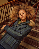 Black Watch Tartan City Transit Coat worn by a child on stairs with fur-lined hood and stylish design.