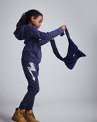 Washed Navy Bolt Sidewalk Sweatpants worn by child holding a top, showcasing comfort and casual style.
