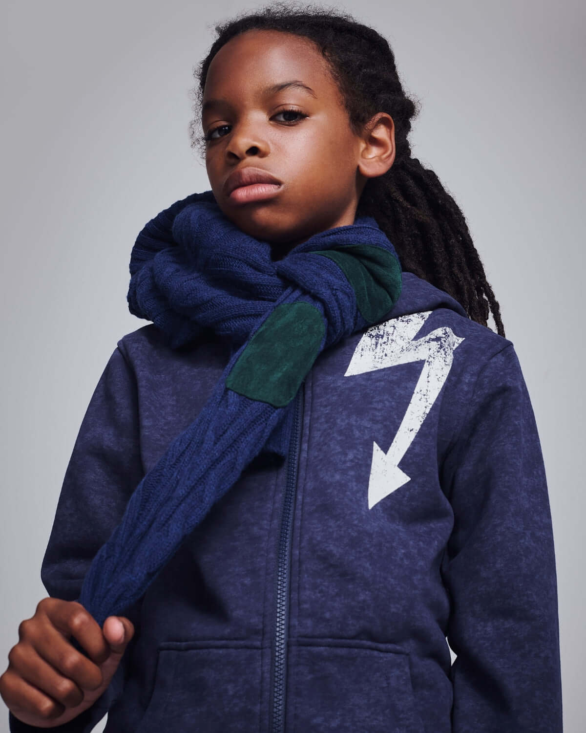 Washed Navy Bolt Strivers Hoodie worn by a kid with a scarf, showcasing street-style vibes.