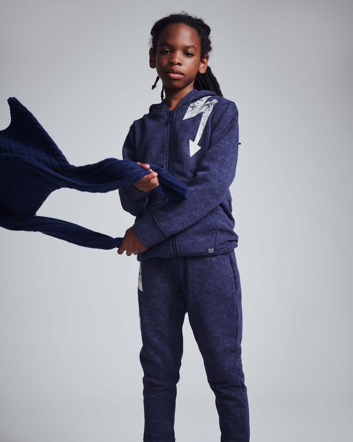 A kid wearing a Washed Navy Bolt Strivers Hoodie, showcasing its comfortable style and casual vibe.