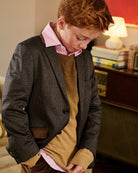 A boy wearing a pink shirt under a brown cardigan. Appaman Fall/Winter 2026 collection.