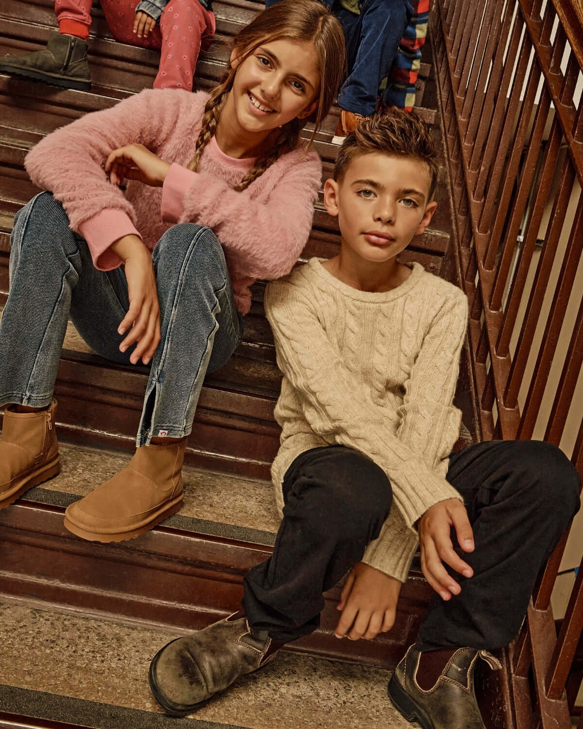 Children wearing stylish outfits, including Pewter Club Pants, while sitting on stairs.