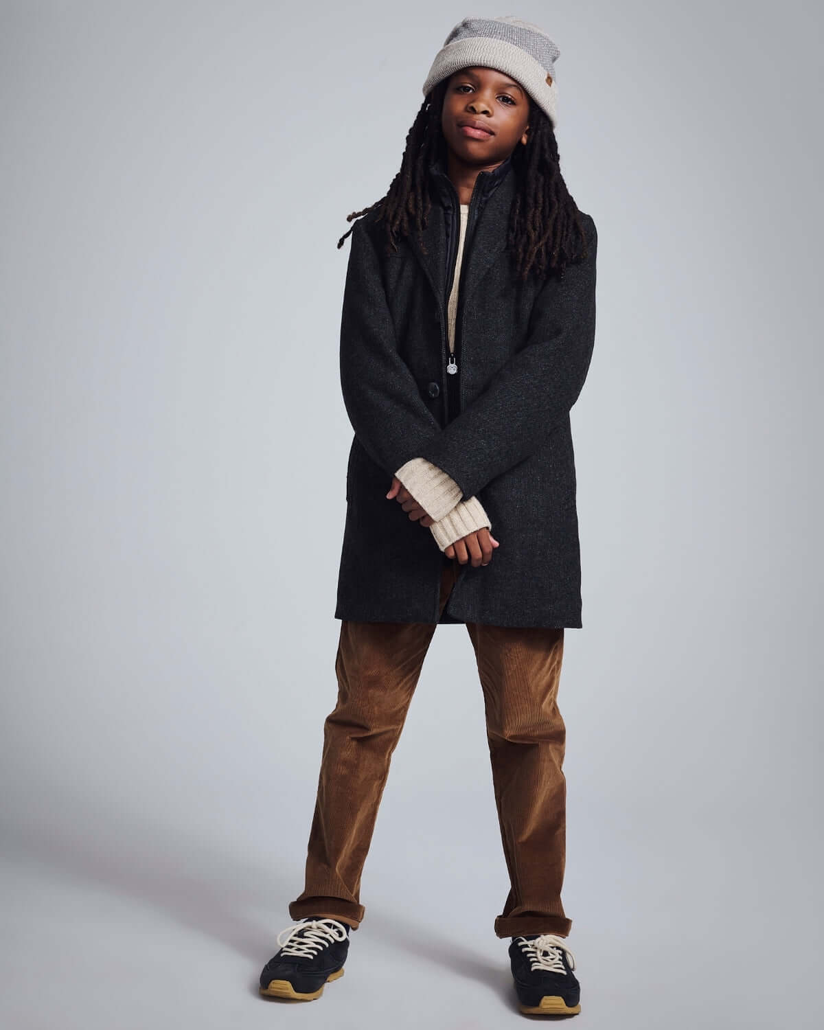 Child wearing a stylish outfit with a coat and British Khaki Cord Club Pants, ready for an adventure.