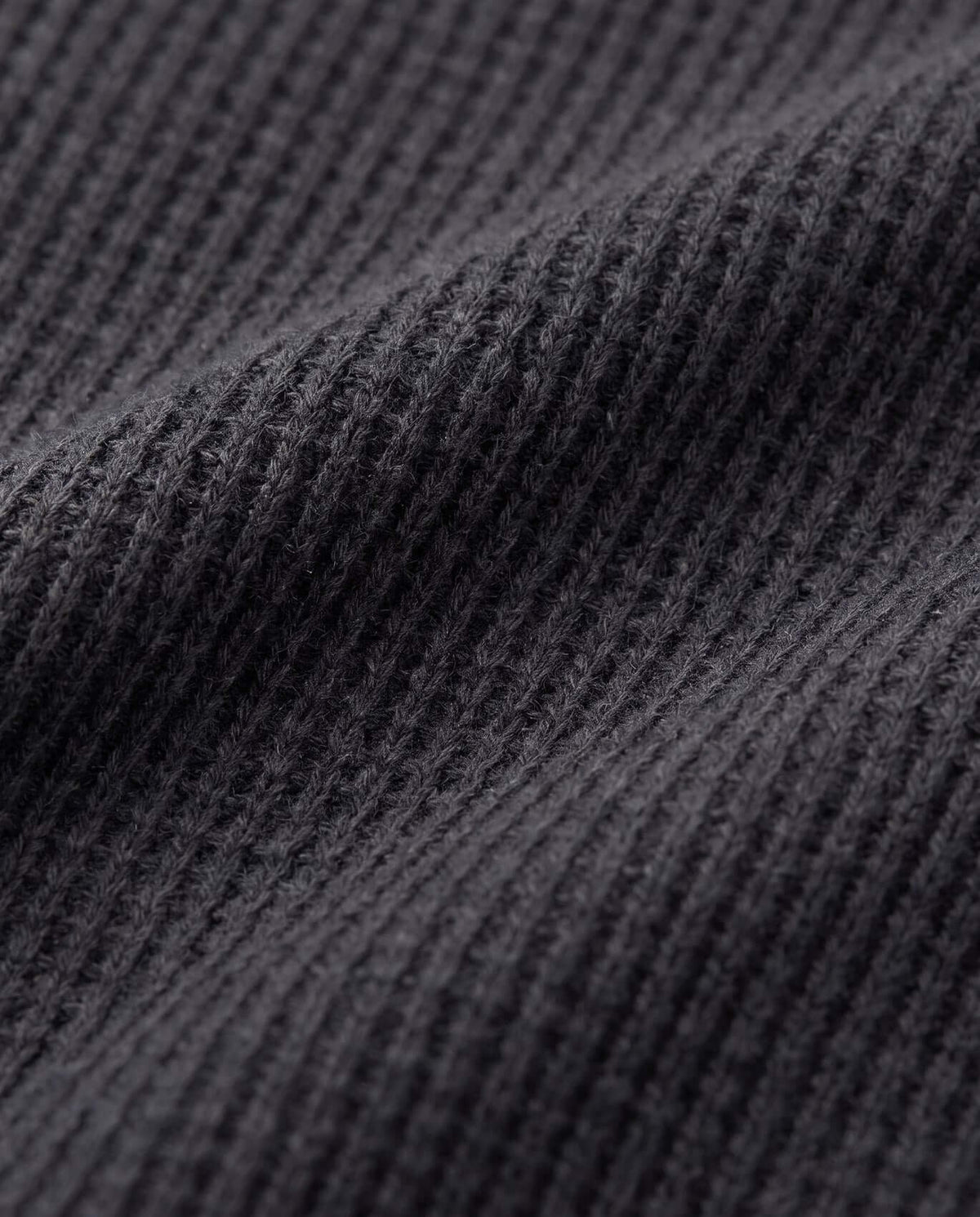 Close-up view of the fabric texture of the Black Craftsman Thermal Henley in cozy thermal waffle knit.