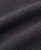 Close-up view of the fabric texture of the Black Craftsman Thermal Henley in cozy thermal waffle knit.