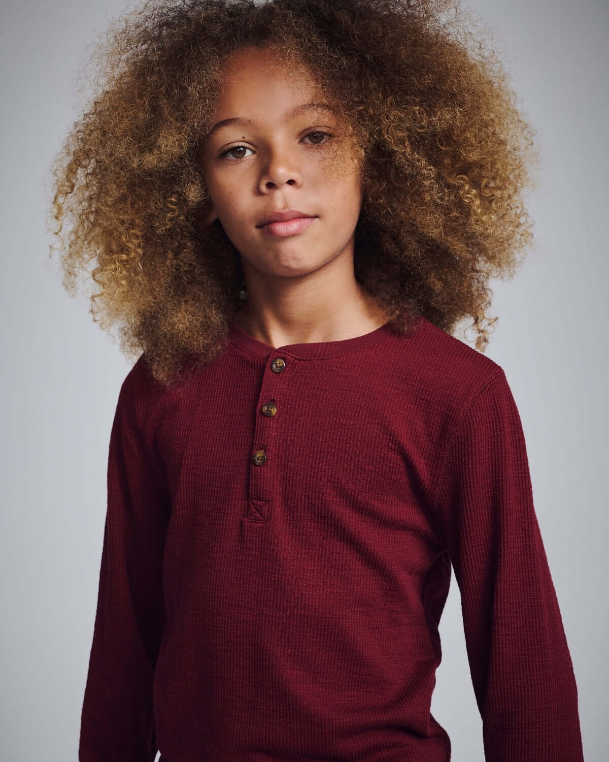Dark Cherry Craftsman Thermal Henley on a young boy with curly hair, showcasing a cozy and stylish look.