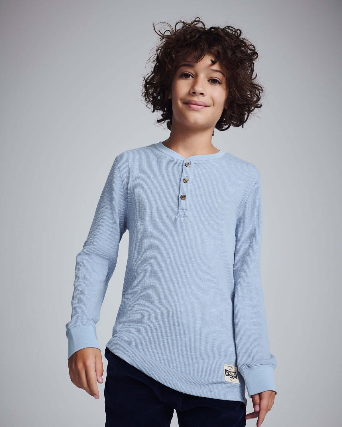 Boy wearing a Dusty Blue Craftsman Thermal Henley, showcasing style and comfort in a thermal design.