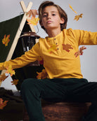 Mustard Craftsman Thermal Henley on a child surrounded by autumn leaves, showcasing style and comfort.