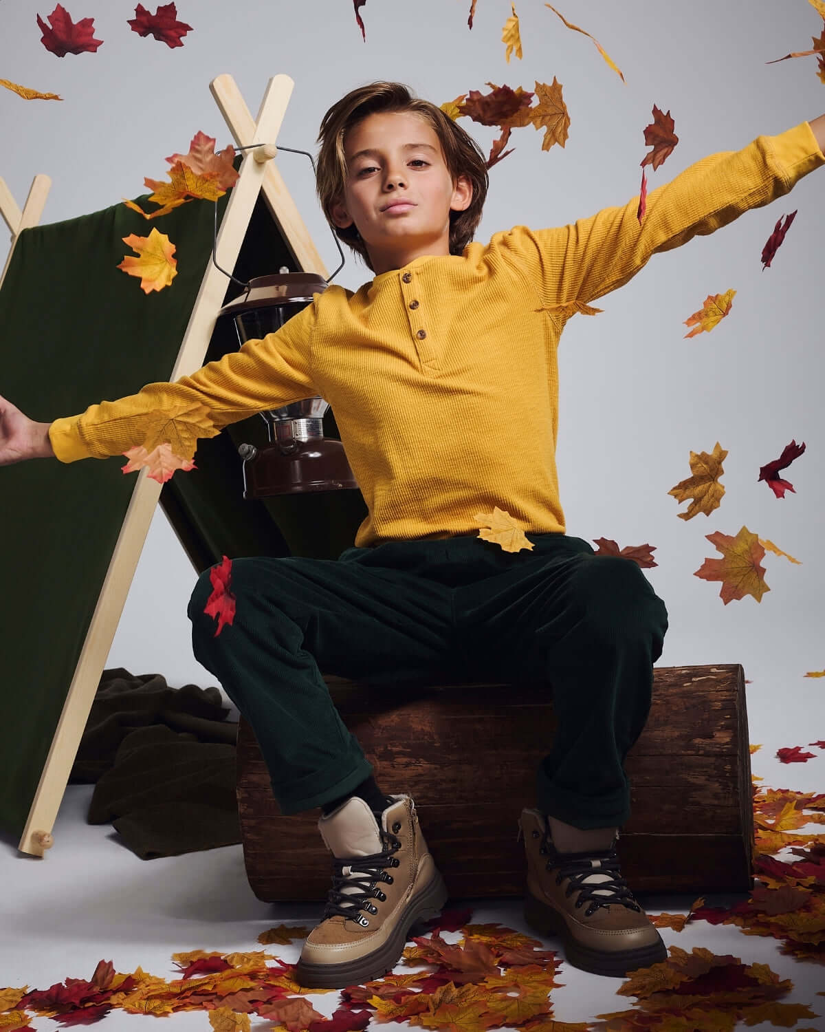 Boy wearing Mustard Craftsman Thermal Henley with colorful leaves, showcasing style and comfort.