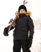 Boy wearing Black Denali Down Coat with ski equipment in winter snow setting.