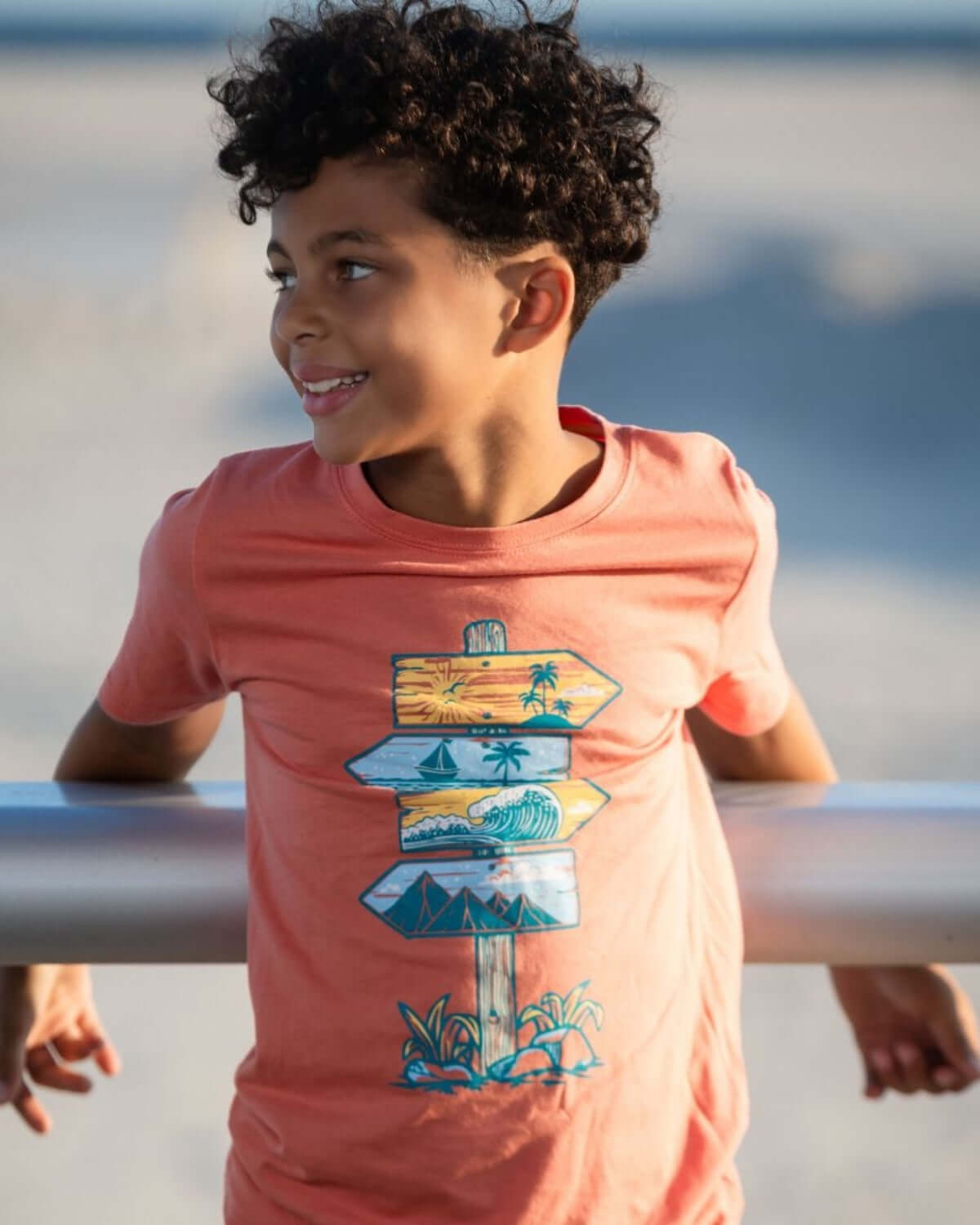 Destination Fun Graphic Tee on a boy, featuring vibrant beach sign graphics perfect for summer adventures.