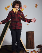 Boy wearing Old English Everyday Stretch Pants, having fun with falling leaves, in a stylish outdoor setting.