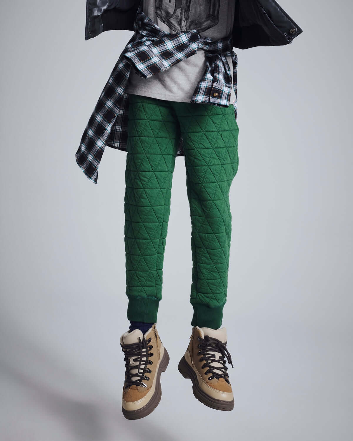 Forest Green Highland Sweatpants worn with a casual outfit, showcasing their quilted fabric and stylish design.