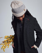 Child wearing the Heather Oatmeal Levi Hat, holding flowers, dressed in stylish outerwear.